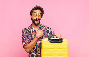 Poster - young bearded man looking excited and surprised pointing to the side and upwards to copy space