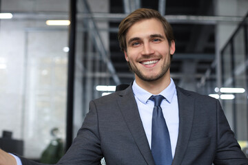 Young handsome businessman smiling in an office environment