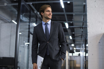 Young handsome businessman smiling in an office environment