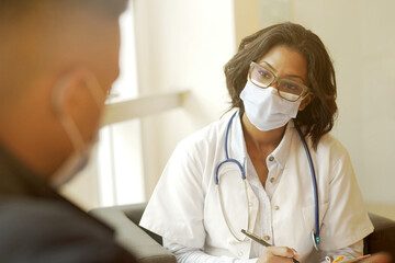 Wall Mural - Woman doctor with patient in office, check-up for 19-ncov