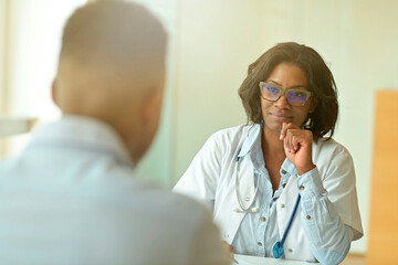 Wall Mural - Portrait of young therapist meeting with patient in medical office