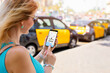 © Kaspars Grinvalds - Woman using ride sharing app on mobile phone
