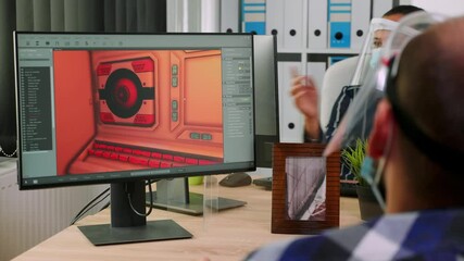 Immobilized game developer sitting in wheelchair with protection face mask working at project from new normal studio office during covid-19 pandemic. handicapped man respecting social distance.