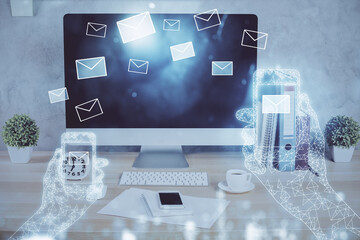 Desktop computer background in office and flying envelops hologram drawing. Double exposure. Electronic mail concept.