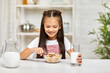© Rychko Yevhen - smiling cute little girl eating breakfast: cereal with the milk in the kitchen. healthy breakfast