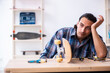 © Elnur - Young man repairing skateboard at workshop