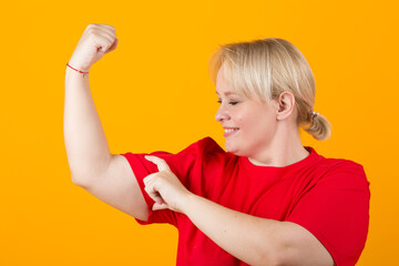 Wall Mural - beautiful young plump female in a red t-shirt on a yellow background