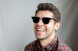 Portrait of a happy young man in black sunglasses and beautiful big smile looking in to the camera 