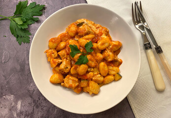 Oven baked gnocchi with chicken strips, tomato sauce, vegetables and cheese.