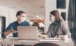 © yurolaitsalbert - business colleagues in protective masks sitting at the office Desk.