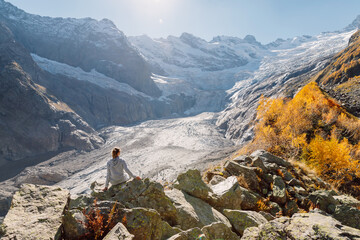 Hiker woman in the mountains. Mountain with glacier and tourist