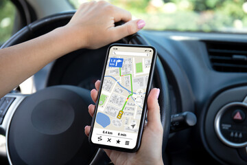 female hands driving car holding phone with navigator app screen