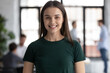 © fizkes - Headshot portrait profile picture of happy young woman employee student standing in office college university at workday looking at camera satisfied proud of being staff member getting good education