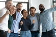 © fizkes - Yes. Overjoyed friendly diverse millennial coworkers standing in office embracing yelling supporting teammate taking part in corporate competition, watching favorite sport crew triumph on wide screen