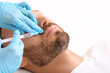 © Prostock-studio - Closeup of man getting lips filler at aesthetic clinic