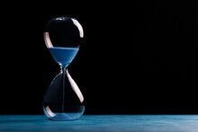 Sandglass, Egg Timer With Blue Sand On Black Background, Time Passing Concept For Business Deadline