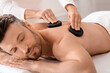 © Prostock-studio - Closeup of man having hot stone massage at luxury spa