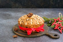 A Traditional Scottish Christmas Fruit Dundee Cake With A Mix Of Dried Fruits, Decorated With Peeled Almonds On A Wooden Board On A Dark Concrete Background.