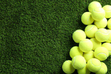 Poster - Heap of tennis balls on green grass, top view. Space for text