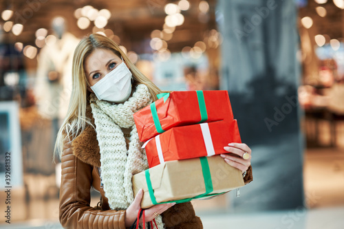 Fotografía Portrait of adult woman shopping in mall wearing a mask, coronavirus concept