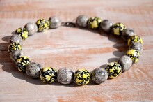 Black And Yellow Beaded Necklace With Floral Pattern On The Table. Handmade Wooden Jewelry