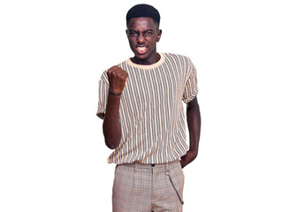 Young african american man wearing casual clothes angry and mad raising fist frustrated and furious while shouting with anger. rage and aggressive concept.