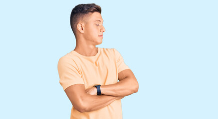 Wall Mural - Young handsome man wearing casual clothes looking to the side with arms crossed convinced and confident