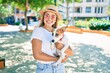 © Krakenimages.com - Young beautiful blonde woman hugging and cuddling puppy dog outdoors