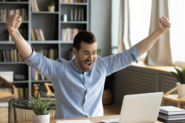 happy businessman looks at laptop screen read great e-mail news raised arms up celebrates career adv