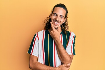 Sticker - Young handsome man with long hair wearing casual clothes looking confident at the camera smiling with crossed arms and hand raised on chin. thinking positive.