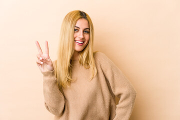 Young blonde caucasian woman showing number two with fingers.