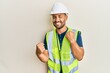 © Krakenimages.com - Handsome man with beard wearing safety helmet and reflective jacket celebrating surprised and amazed for success with arms raised and eyes closed