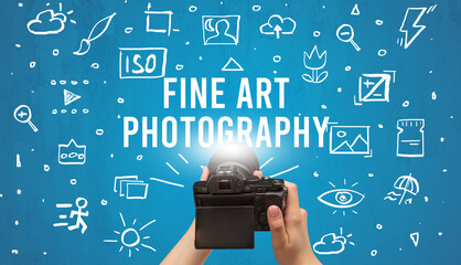 Hand taking picture with digital camera and FINE ART PHOTOGRAPHY inscription, camera settings concept