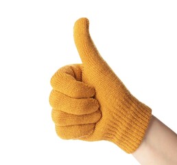 Woman in yellow woolen glove showing thumb up gesture on white background, closeup. Winter clothes