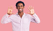 African handsome man wearing casual pink shirt showing and pointing up with fingers number ten while smiling confident and happy.