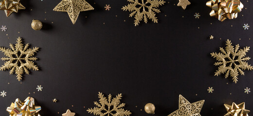 Top view of golden snowflake, stars and Christmas ball on black background with copy space for text. Black Friday Sale, Banner, poster composition.