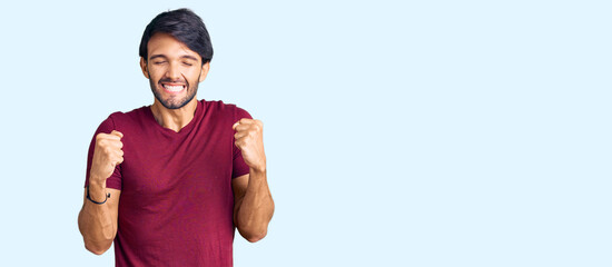 Poster - Handsome hispanic man wearing casual clothes excited for success with arms raised and eyes closed celebrating victory smiling. winner concept.