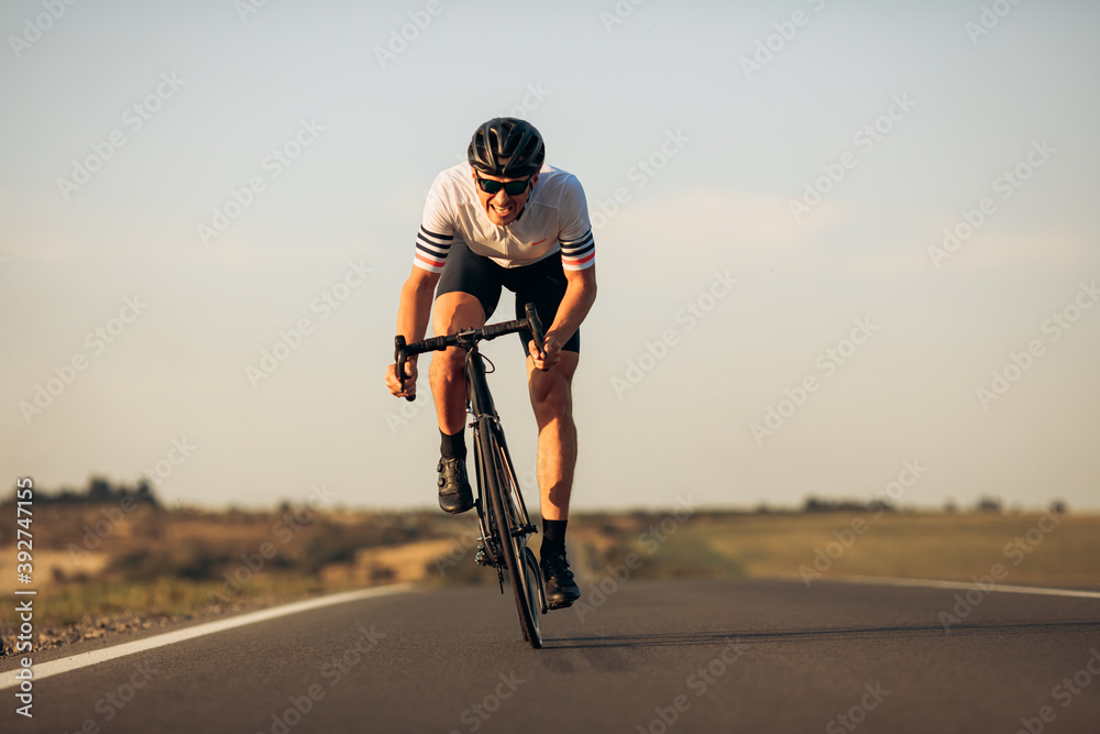 Happy road cyclist in protective helmet training outdoors - obrazy, fototapety, plakaty 