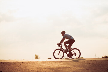 Wall Mural - Active cyclist in sport clothing racing on road