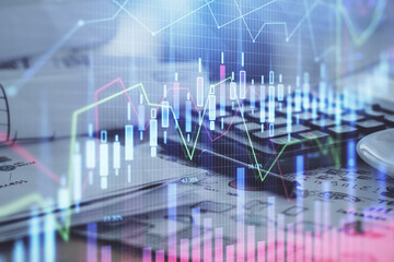 Double exposure of financial chart drawings and desk with open notebook background. Concept of forex market