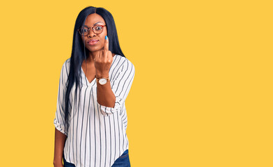 Poster - Young african american woman wearing casual clothes and glasses showing middle finger, impolite and rude fuck off expression