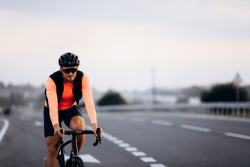 Wall Mural - Young guy with muscular body cycling on road