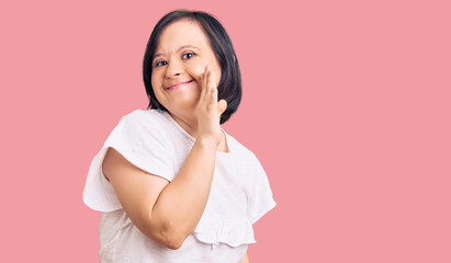 Canvas Print - Brunette woman with down syndrome wearing casual white tshirt hand on mouth telling secret rumor, whispering malicious talk conversation