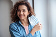 © Stock 4 You - Happy Hispanic young woman takes off protective mask indoors.