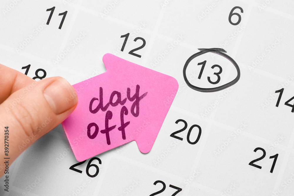 Woman marking day off in calendar, closeup