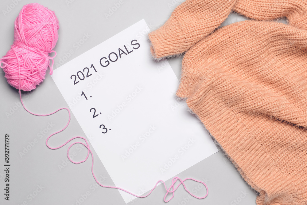 Empty to do list on 2021 year with knitting yarn and sweater on light background