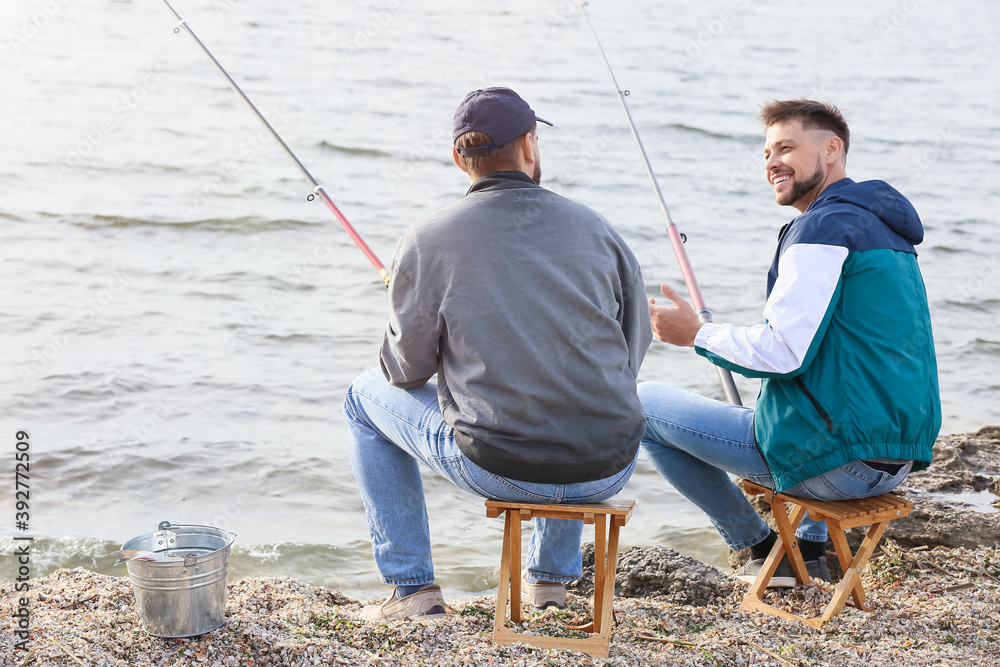 Young men fishing on river