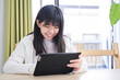 © mapo - リビングでタブレットを見る日本人女子中学生