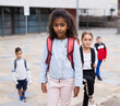 © JackF - Portrait of smiling schoolgirl standing on the street, kids on background
