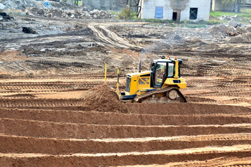 bulldozer on construction site job of burying the old building